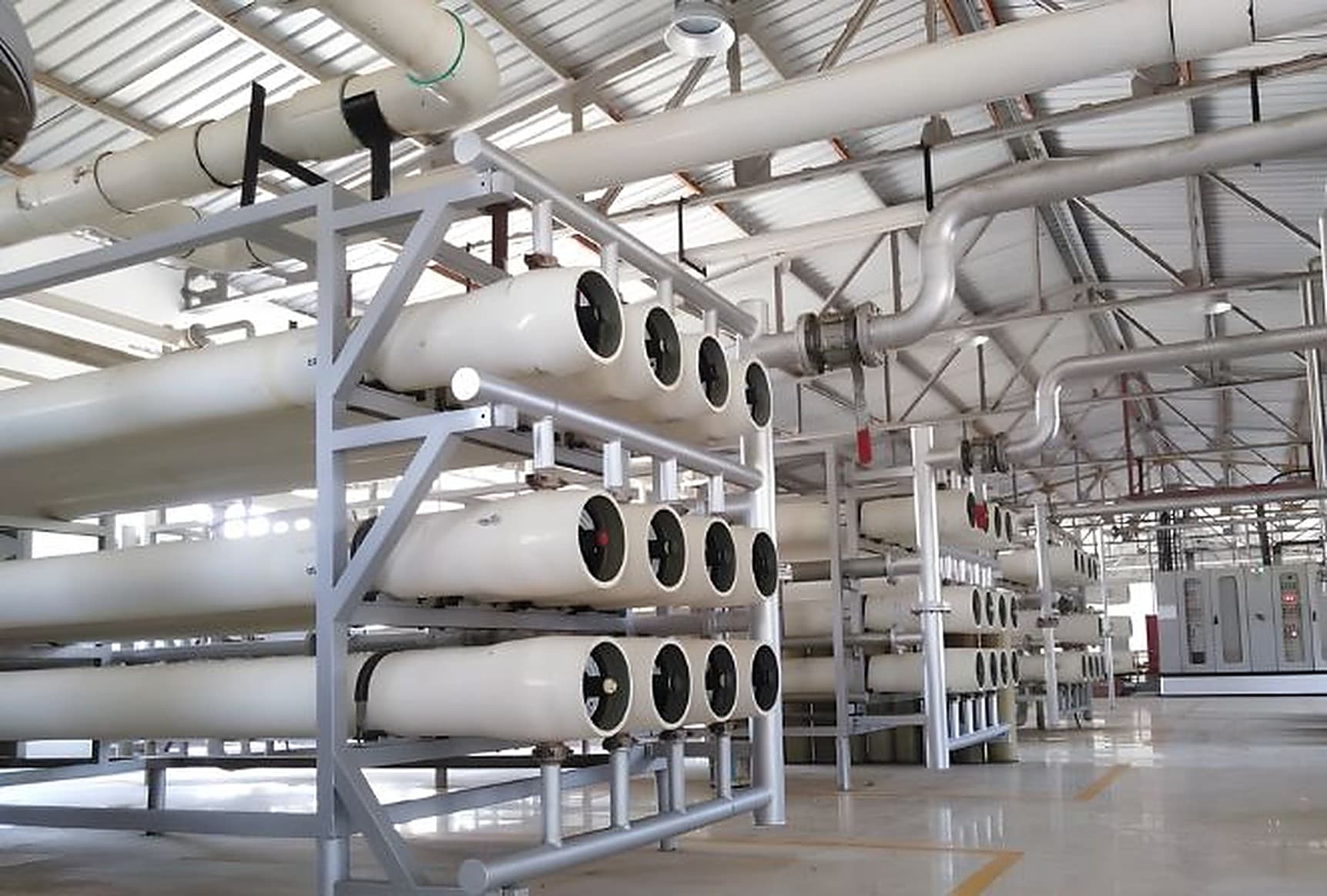 Industrial reverse osmosis plant with membrane pressure vessel skids installed in a treatment hall