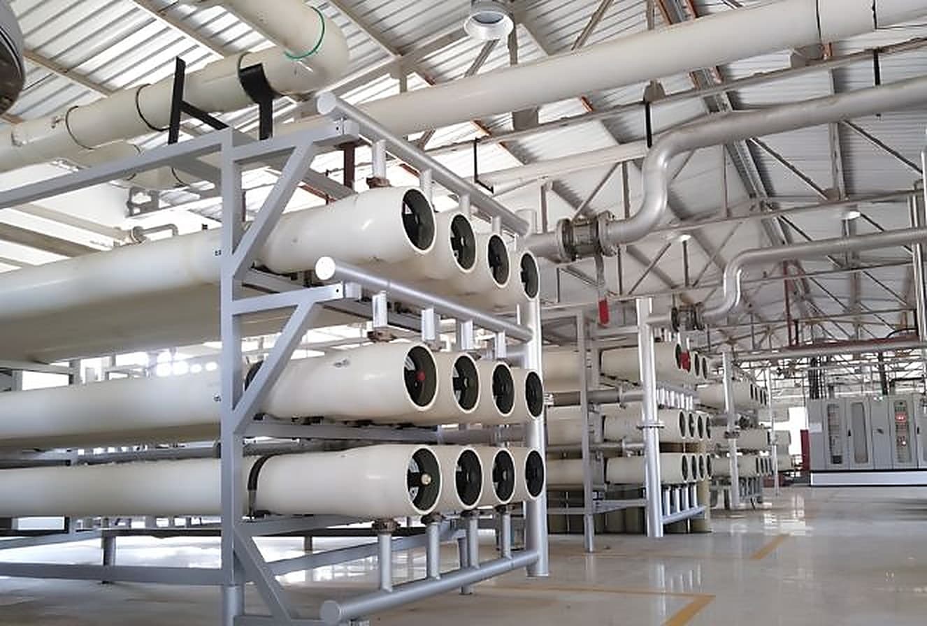 Industrial reverse osmosis plant with multiple membrane pressure vessel skids in a treatment hall