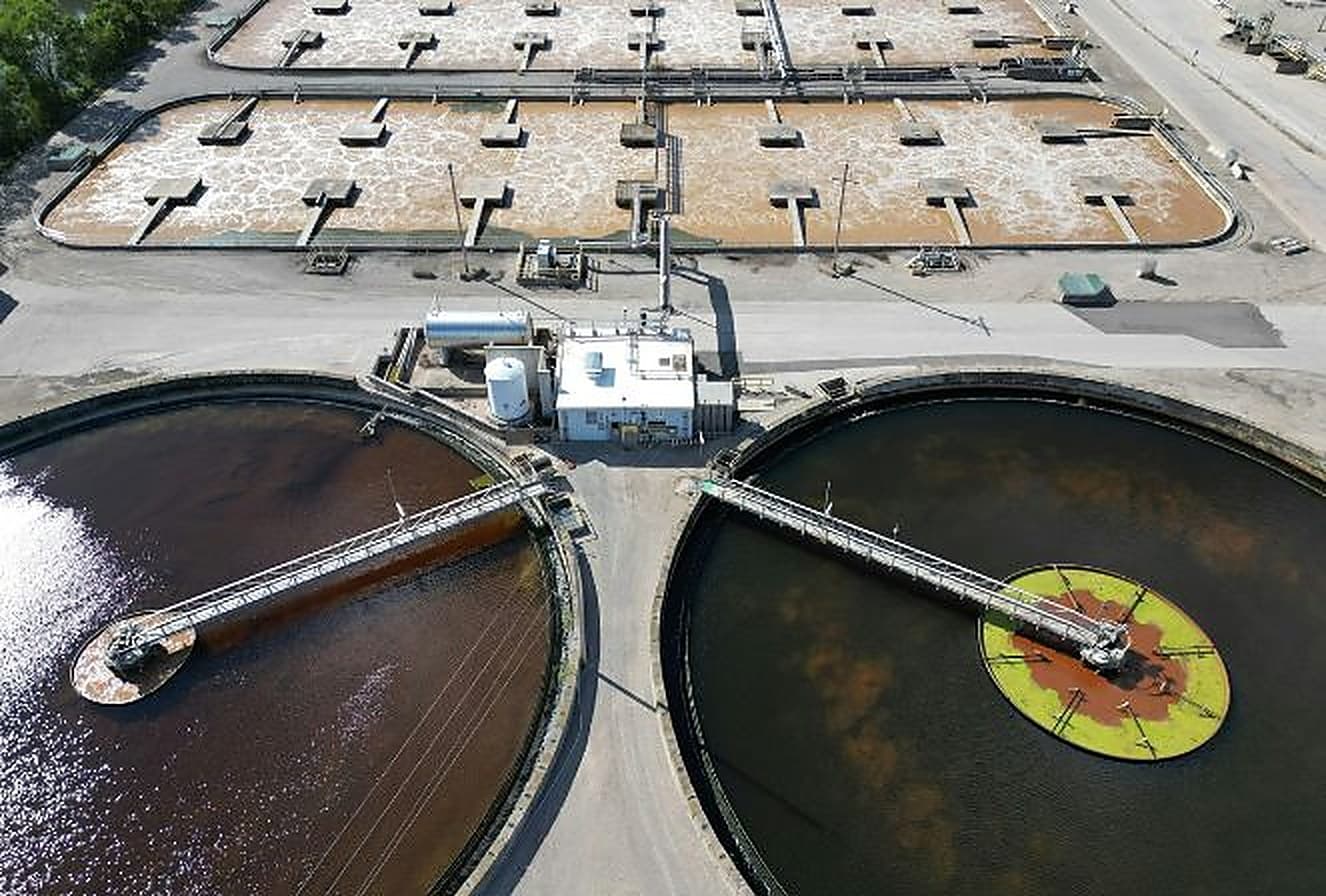 Aerial view of a sewage treatment plant showing circular clarifiers and aeration basins